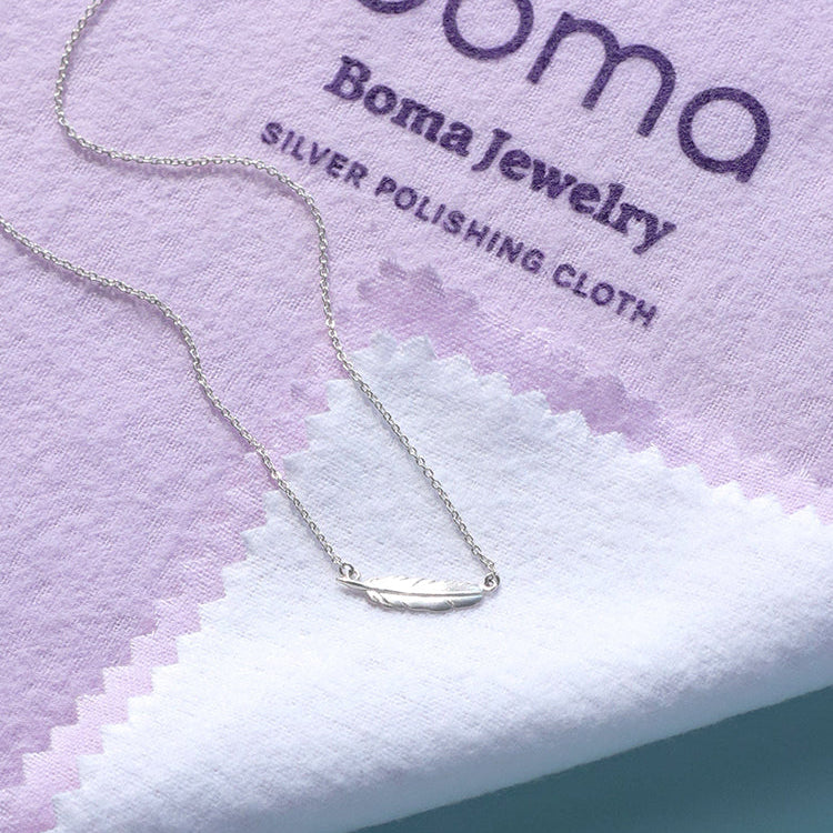 a boma jewelry sterling silver polishing cloth that is purple with turquoise color paper background