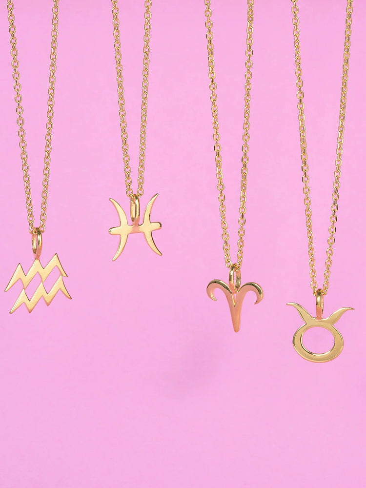 14k gold plated necklaces over sterling silver in 4 zodiac symbols displayed against a soft pink background